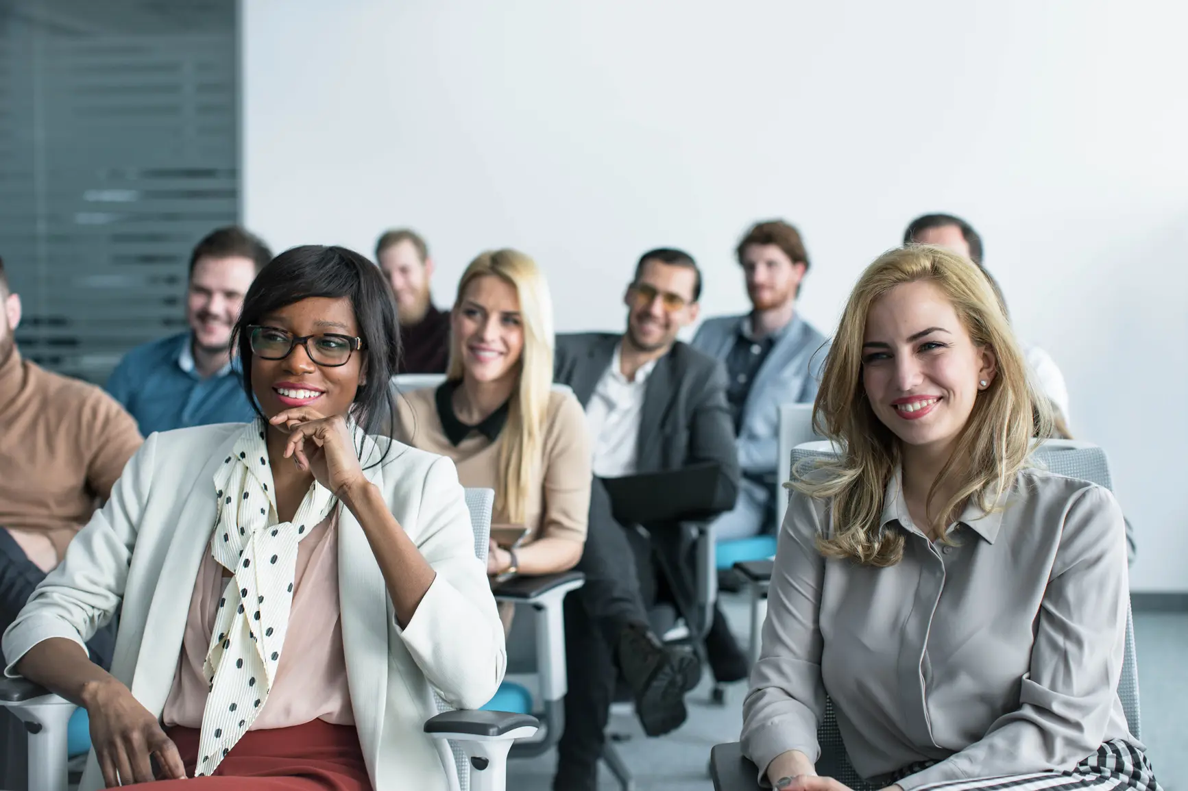 A group of seminar participants listen intently to the speaker.