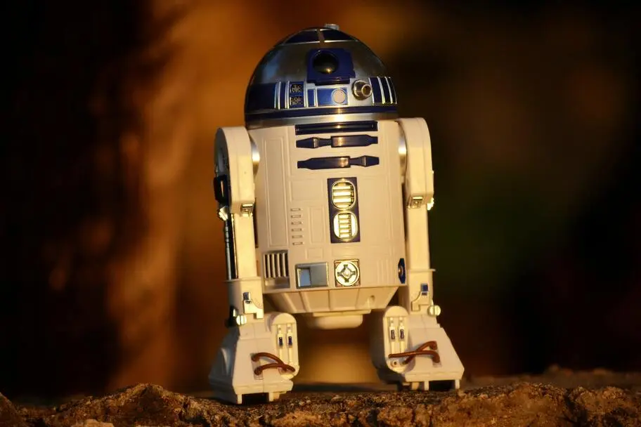 R2-D2, the fictional robot character from the Star Wars movies, is standing on a rock base.