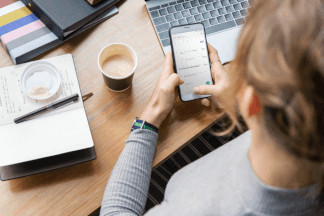 Vogelperspektive auf einen Schreibtisch mit Laptop, Kaffeebecher und Notizblock. Sichere Exchange-Alternative aus Deutschland von luckycloud