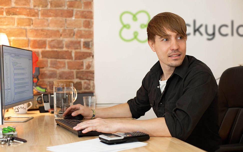 Luc Mader, the founder of luckycloud, is sitting at his desk working.