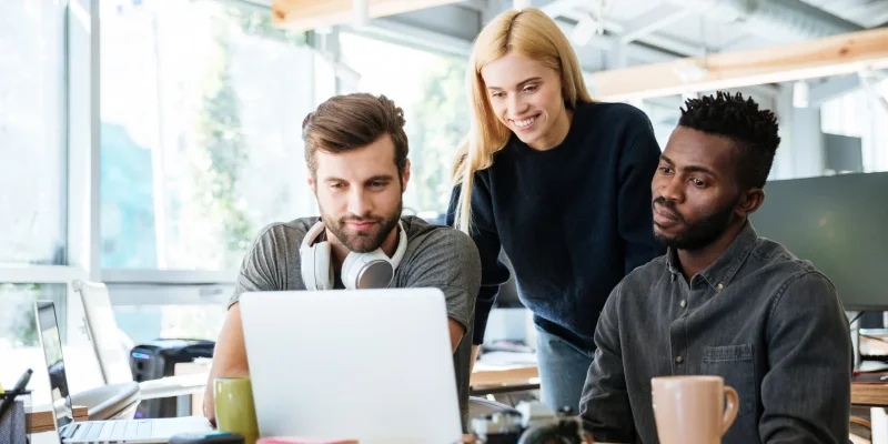 Junges Startup-Team schaut gemeinsam auf Bildschirm mit Cloud-Infrastruktur von luckycloud