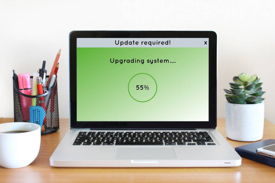 Ein geoeffneter Laptop zeigt die Schrift "Upgrading System". Der Ladekreis hat 55 Prozent bereits erreicht.